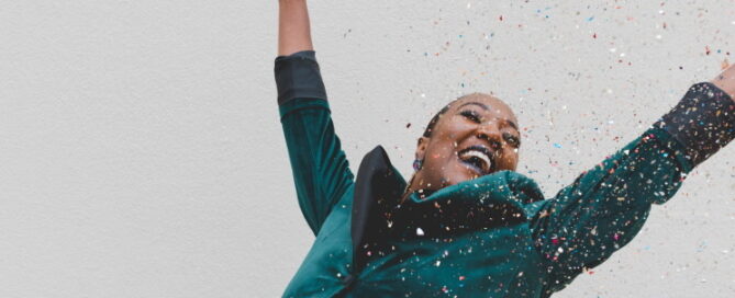 Woman celebrating and throwing confetti in the air